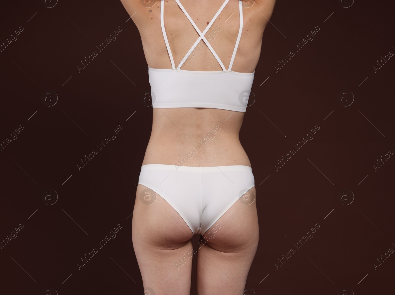 Photo of Woman with slim body on brown background, closeup