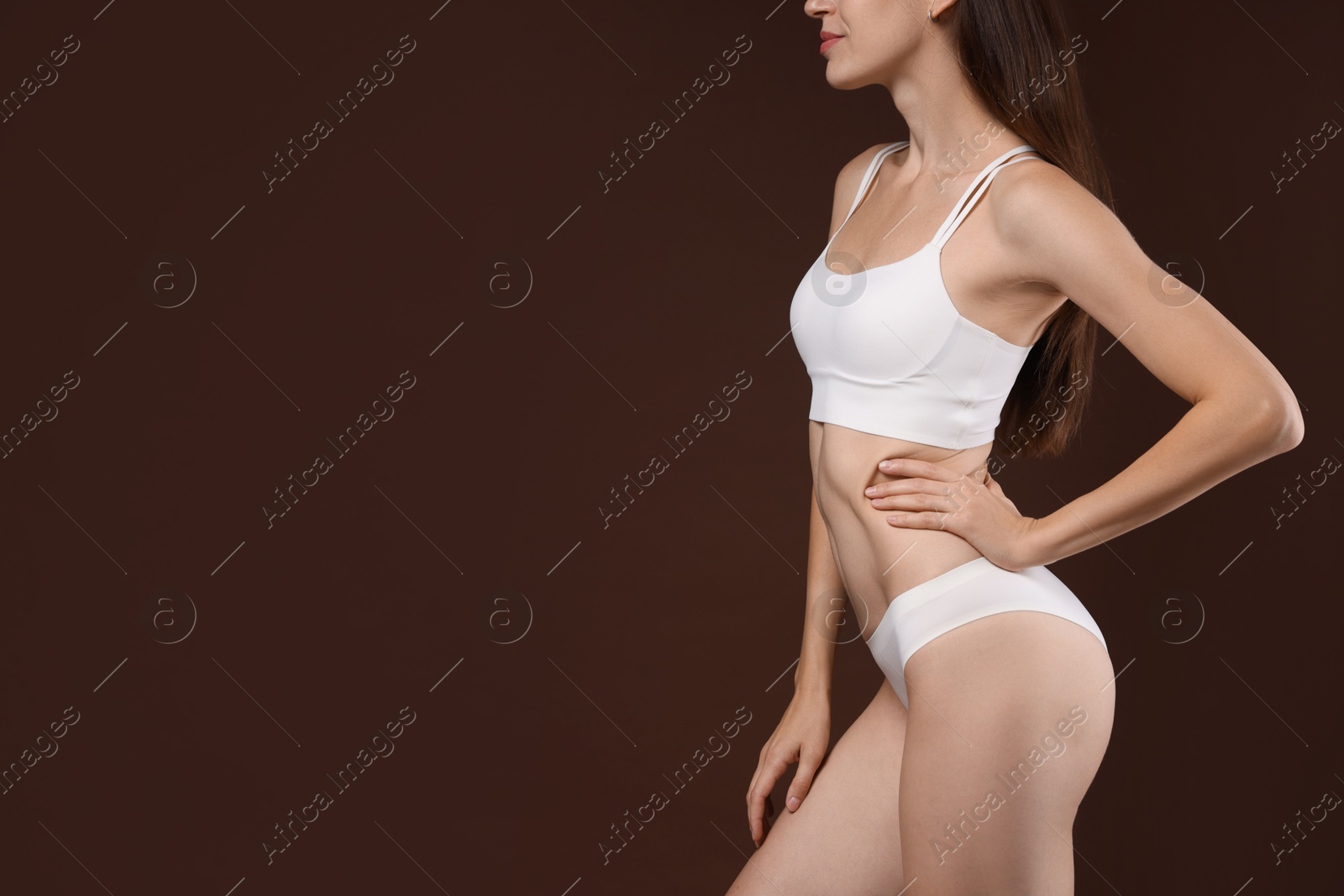 Photo of Woman with slim body on brown background, closeup. Space for text