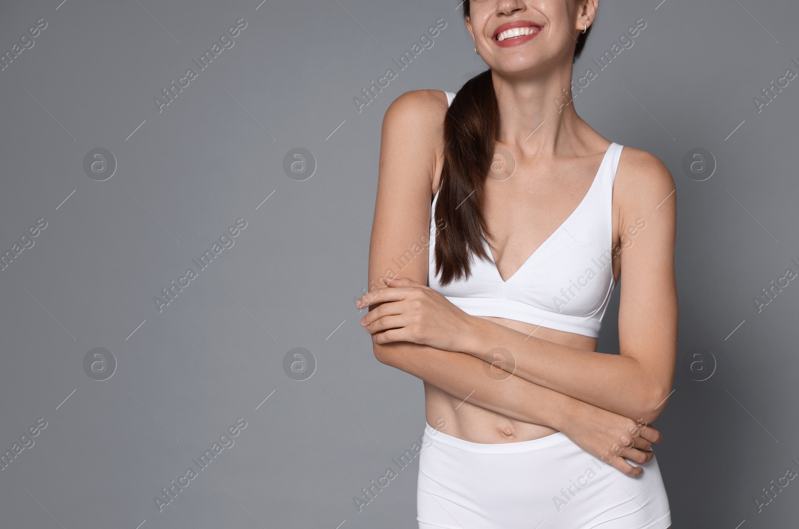 Photo of Woman with slim body on grey background, closeup. Space for text