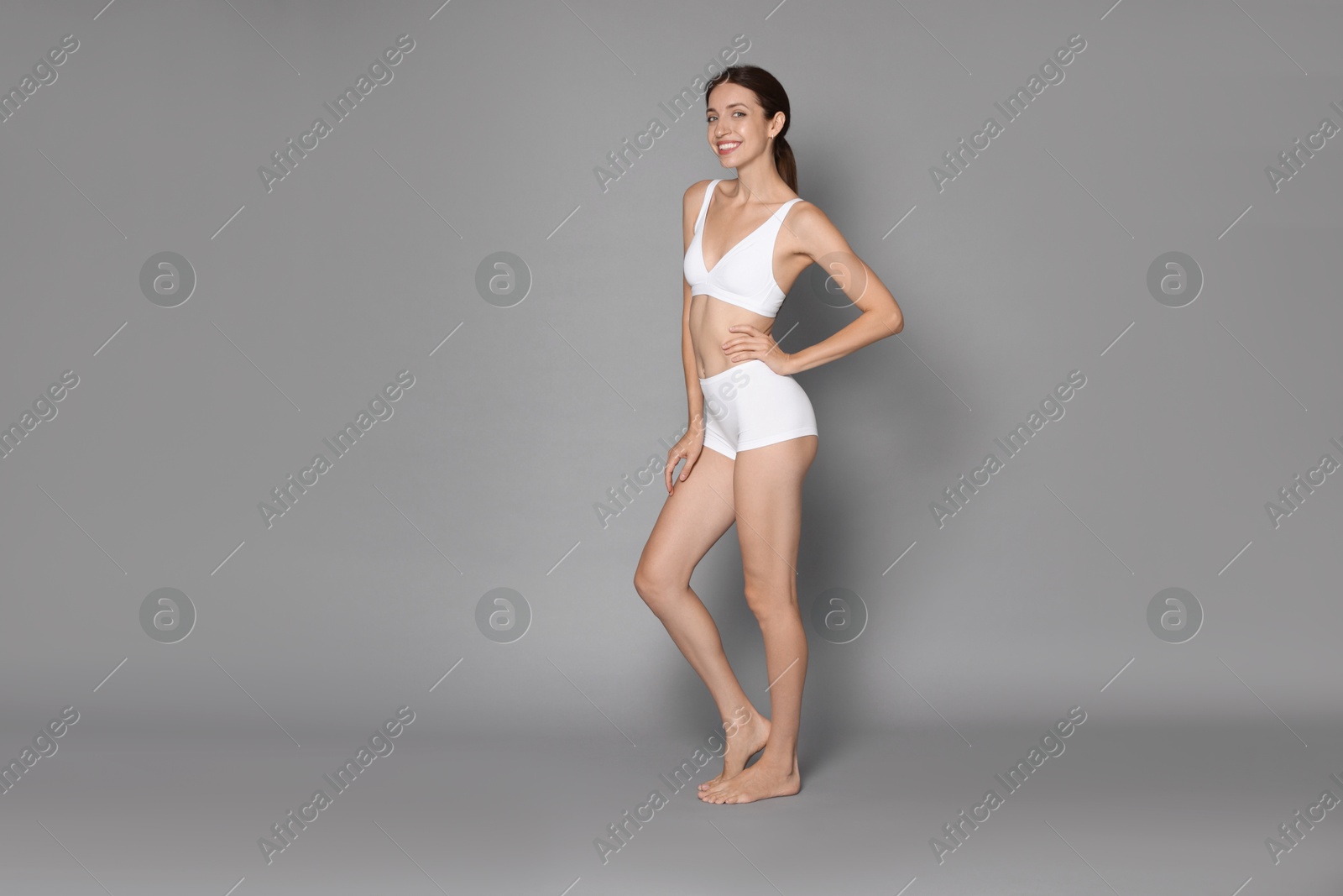 Photo of Woman with slim body on grey background