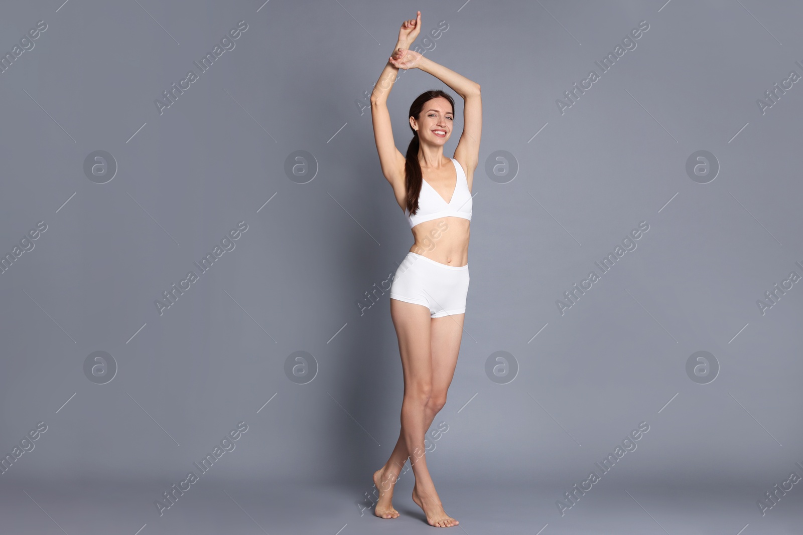 Photo of Woman with slim body on grey background
