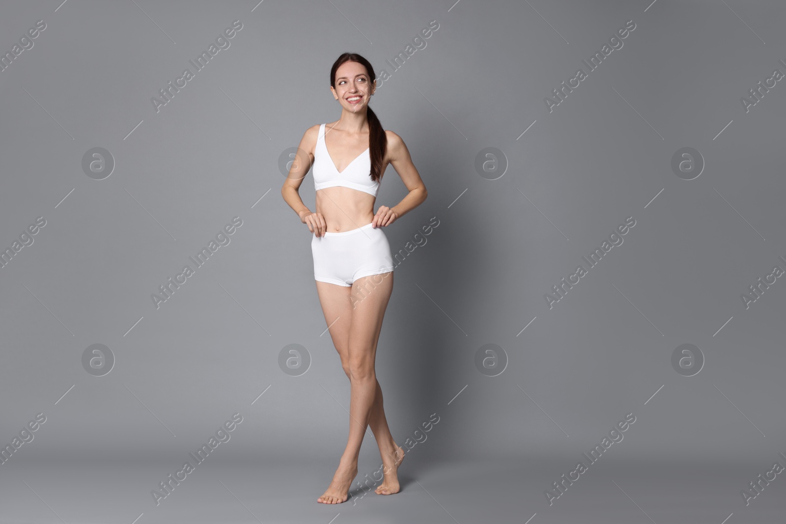 Photo of Woman with slim body on grey background