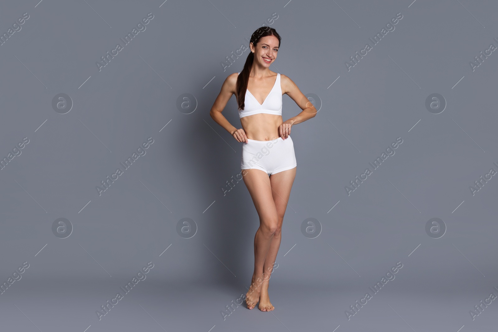 Photo of Woman with slim body on grey background
