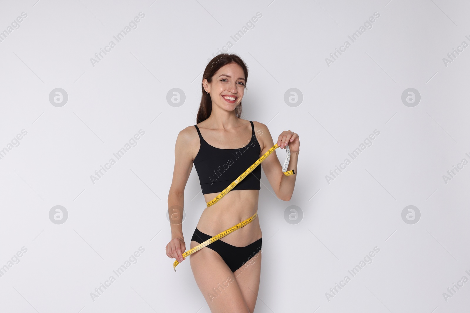 Photo of Woman with slim body and measuring tape on white background