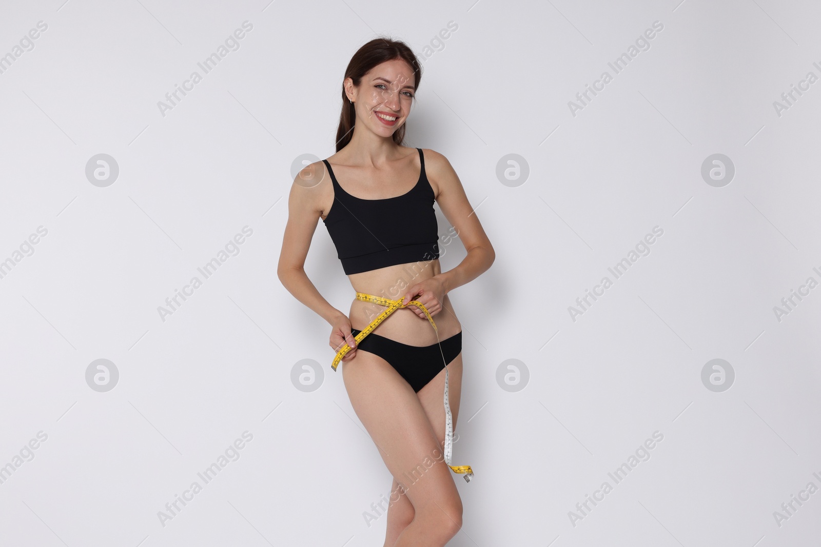 Photo of Woman with slim body and measuring tape on white background