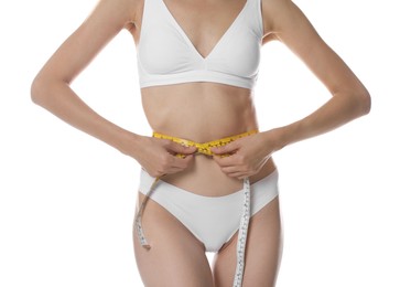 Photo of Woman with slim body measuring waist circumference on white background, closeup
