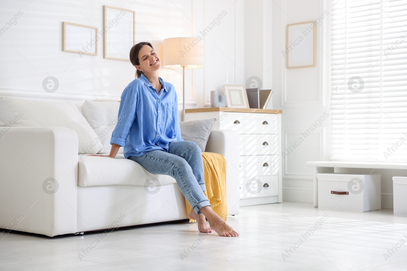 Photo of Positive woman on sofa at home. Space for text