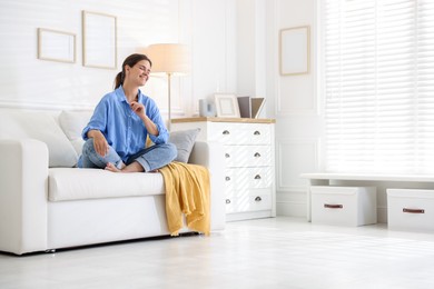 Photo of Positive woman on sofa at home. Space for text