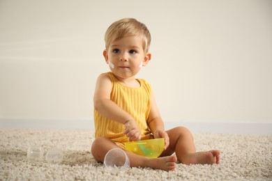 Photo of Cute baby with cream on his body playing at home