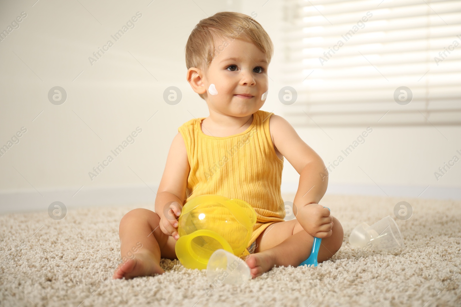 Cute baby with cream on his body playing at home Photo of Cute baby with cream on his body playing at home