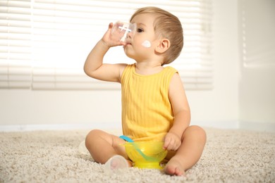 Photo of Cute baby with cream on his body playing at home