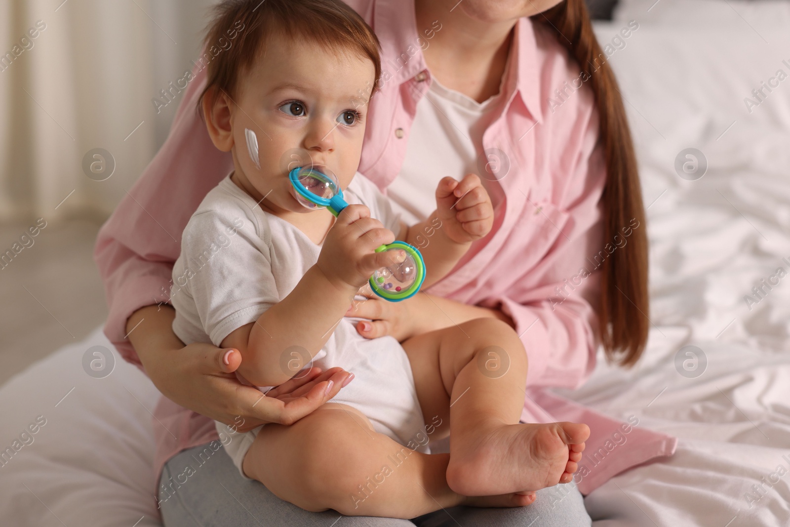 Photo of Mother and baby with cream on his face at home, closeup