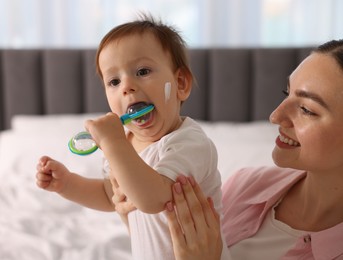 Photo of Mother and baby with cream on his face at home