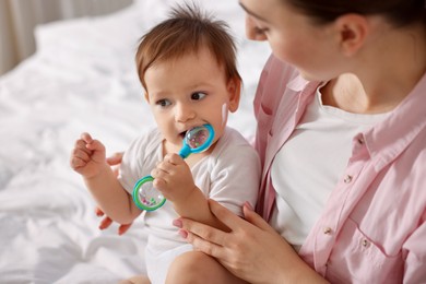 Photo of Mother and baby with cream on his face at home, closeup