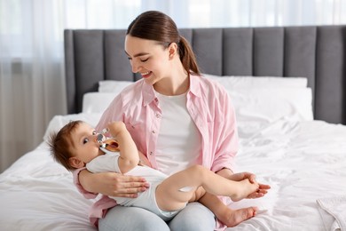 Photo of Mother and baby with cream on his leg at home
