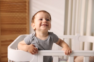 Photo of Cute little baby in crib at home