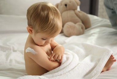 Photo of Cute baby with cream on his shoulder at home