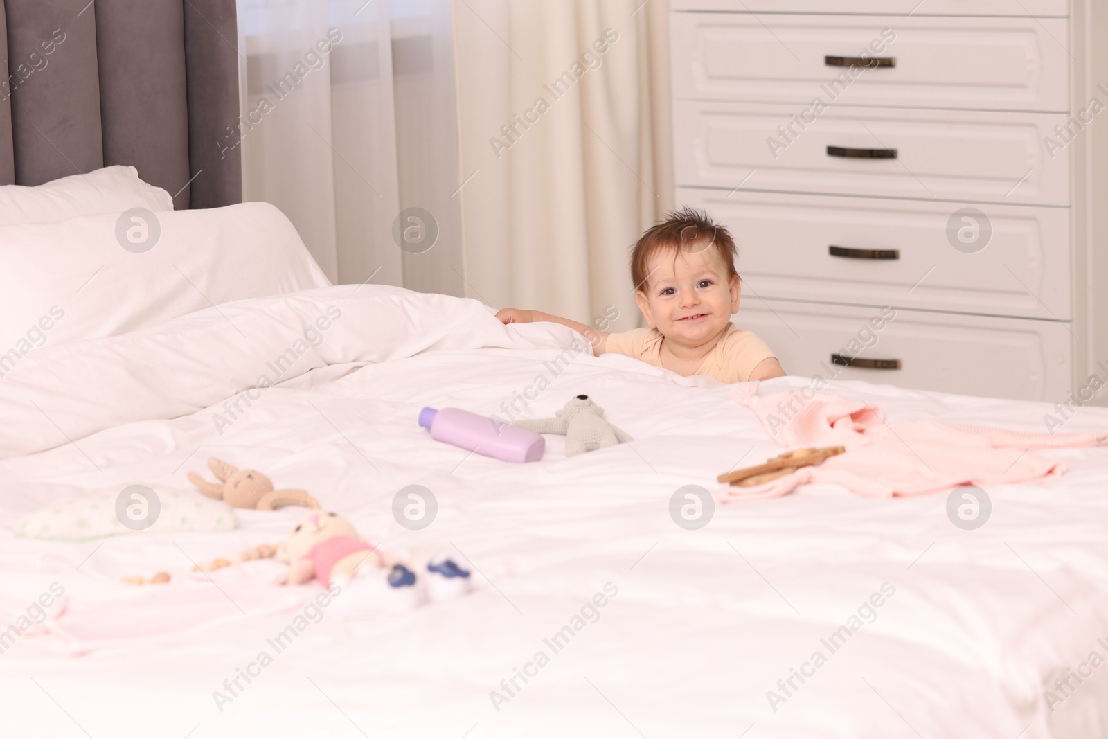 Photo of Cute little baby near bed at home