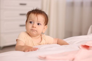 Photo of Cute little baby near bed at home