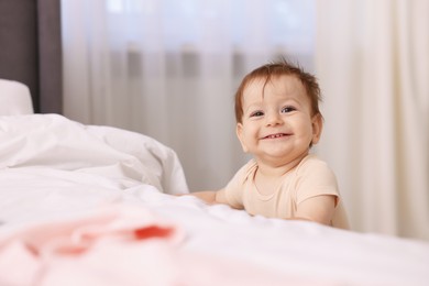 Photo of Cute little baby near bed at home