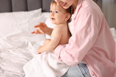 Photo of Mother applying cream onto her baby's arm at home, closeup