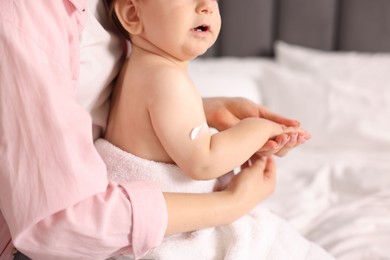 Photo of Mother and baby with cream on his arm at home, closeup