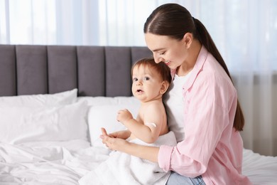 Photo of Mother and baby with cream on his arm at home. Space for text