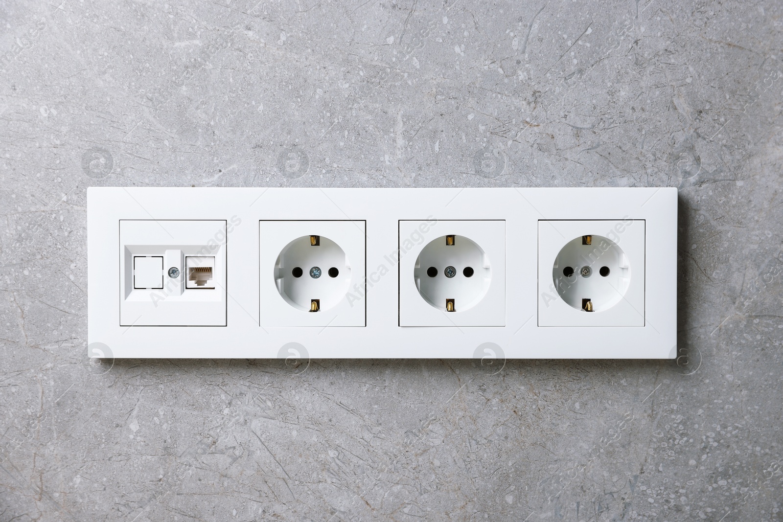 Photo of Electric power sockets on grey wall indoors