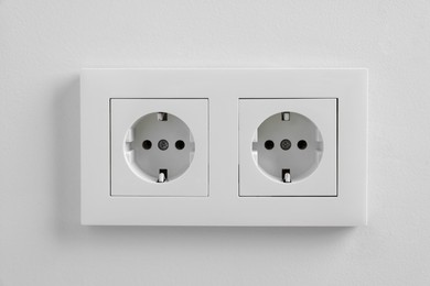 Photo of Electric power sockets on white wall indoors