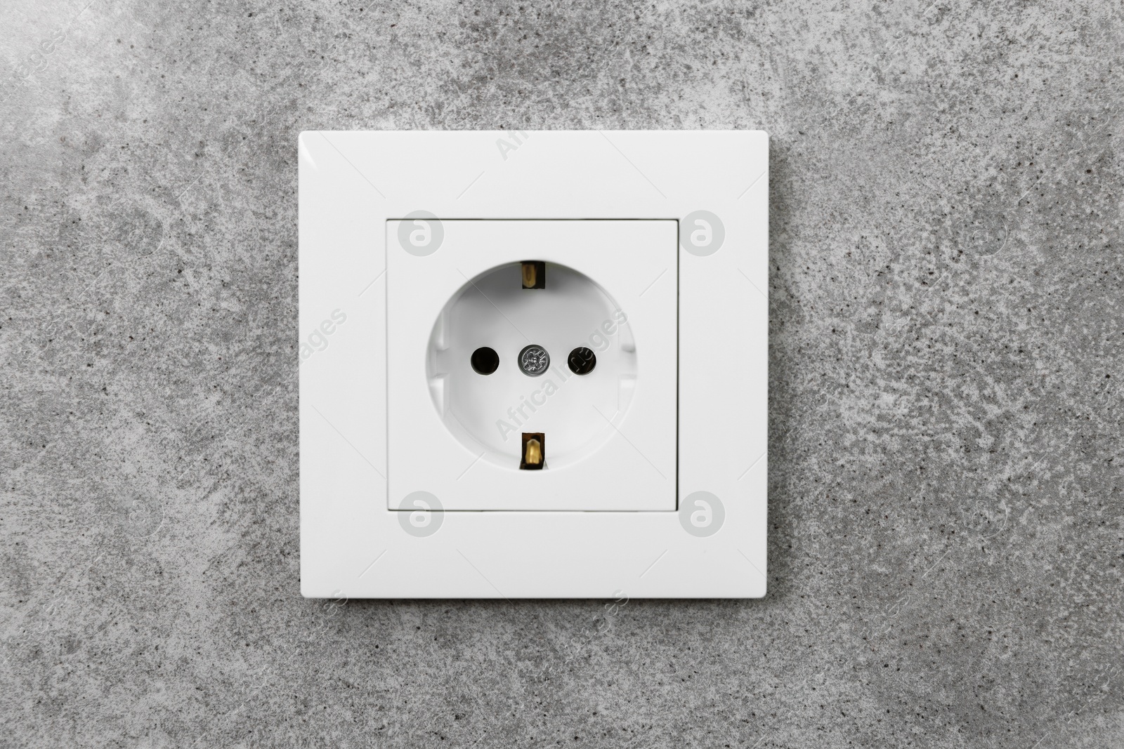 Photo of Electric power socket on grey wall indoors