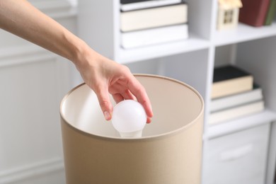 Photo of Woman changing light bulb in lamp at home, closeup
