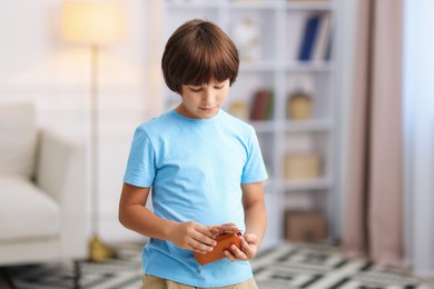 Photo of Boy putting his pocket money into wallet at home