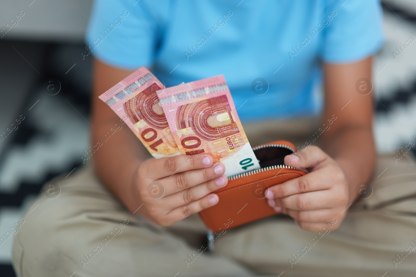 Photo of Boy with pocket money on floor at home, closeup