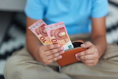 Photo of Boy with pocket money on floor at home, closeup