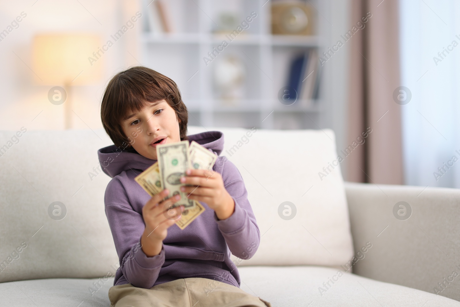Photo of Boy with pocket money on sofa at home. Space for text