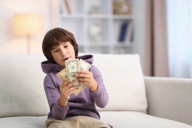 Photo of Boy with pocket money on sofa at home. Space for text