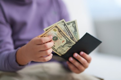 Photo of Boy putting his pocket money into wallet at home, closeup