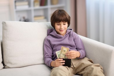 Photo of Boy with pocket money on sofa at home