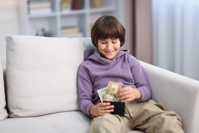 Photo of Boy with pocket money on sofa at home