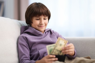 Photo of Boy with pocket money on sofa at home