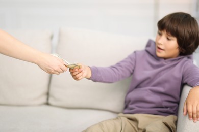 Photo of Mother giving her son pocket money at home, closeup