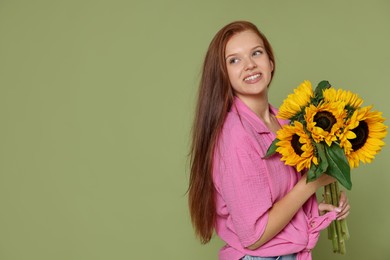 Photo of Teenage girl with bouquet of beautiful sunflowers on green background, space for text
