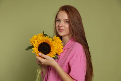 Photo of Teenage girl with beautiful sunflowers on green background