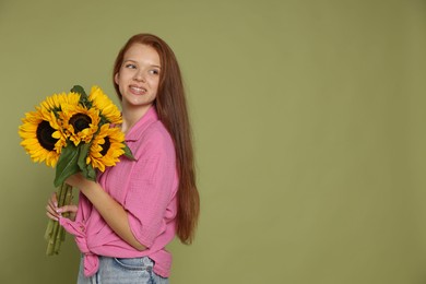Photo of Teenage girl with bouquet of beautiful sunflowers on green background, space for text