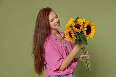 Photo of Teenage girl with bouquet of beautiful sunflowers on green background