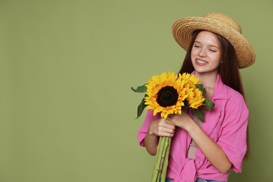 Photo of Teenage girl with beautiful sunflowers on green background, space for text