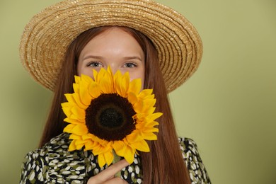 Photo of Teenage girl with beautiful sunflower on green background
