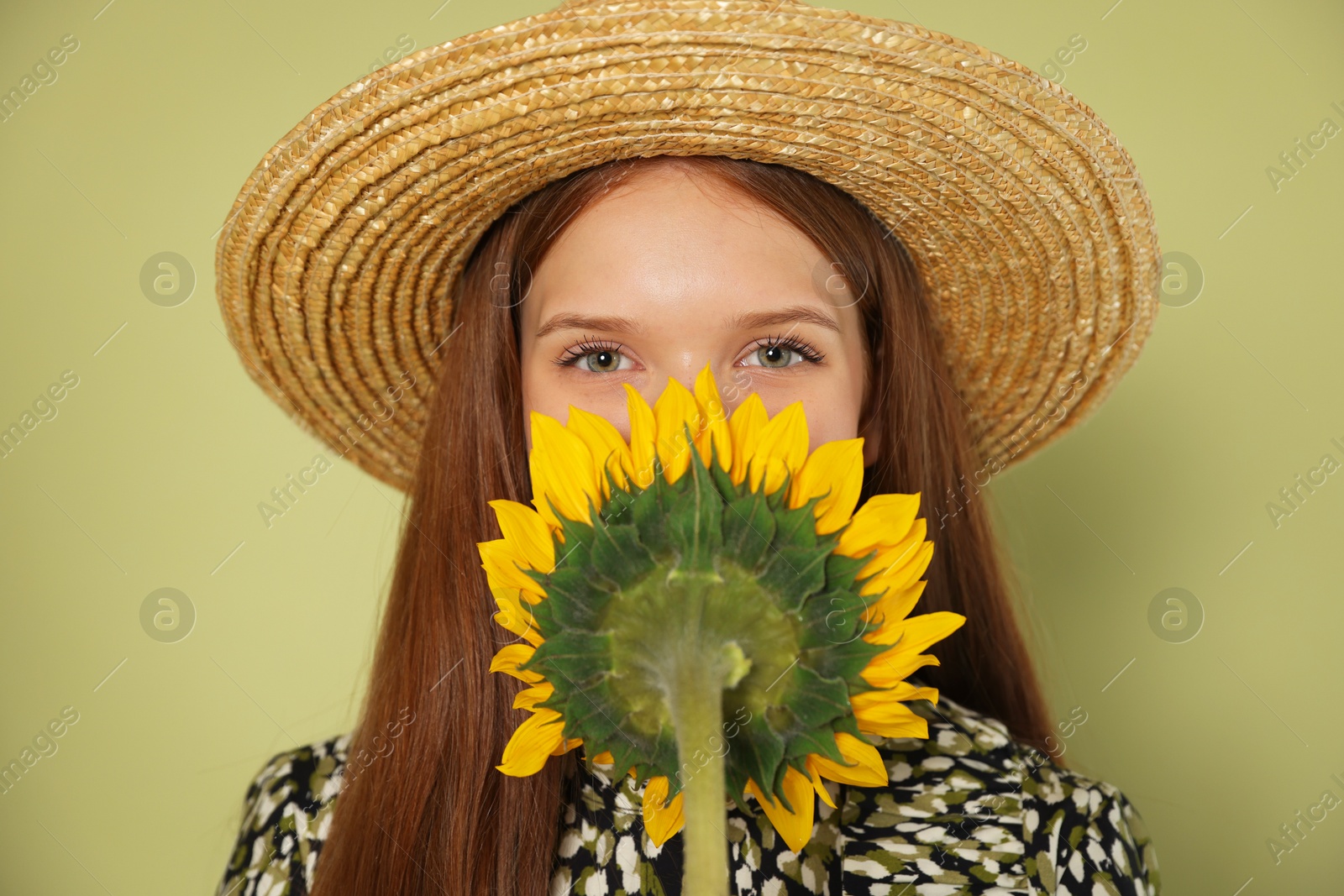 Photo of Teenage girl with beautiful sunflower on green background