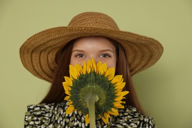 Photo of Teenage girl with beautiful sunflower on green background