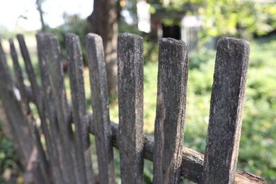 Photo of Wooden fence in yard on sunny day, closeup